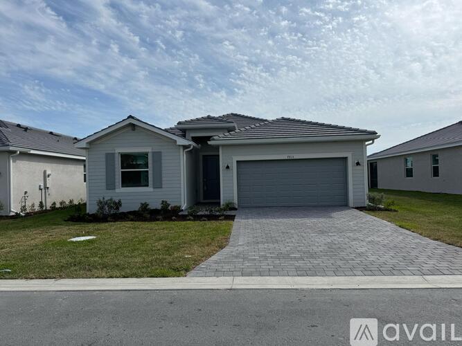 A house with a grey garage door is for sale.