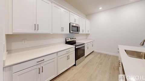A kitchen with white cabinets and a black stove top oven.