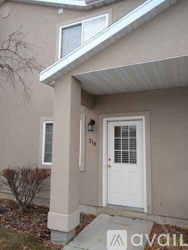A beige house with a white door and a window.
