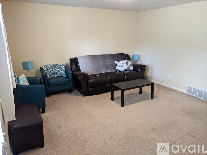A living room with a brown couch and a blue chair.