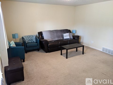 A living room with a brown couch and a blue chair.