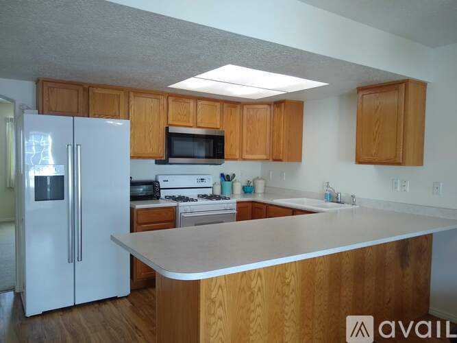 A kitchen with wooden cabinets and a white refrigerator.