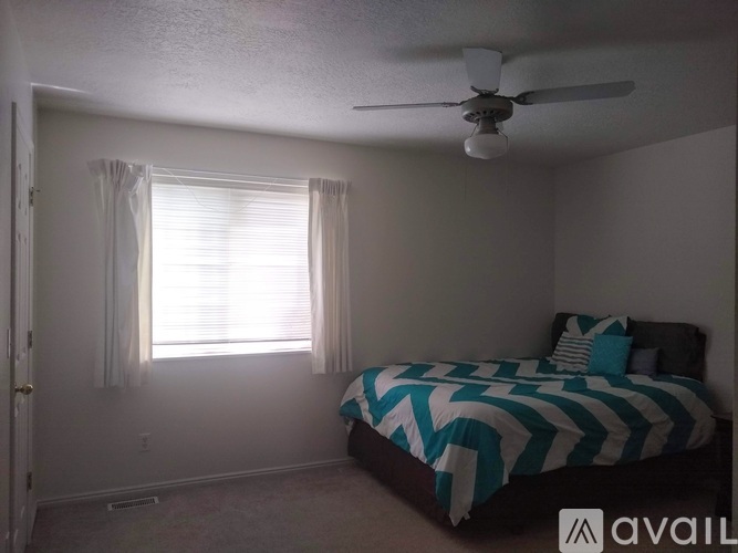 A bedroom with a bed and a window with curtains.