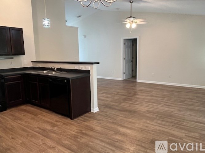 A kitchen with dark wood cabinets and a black refrigerator.