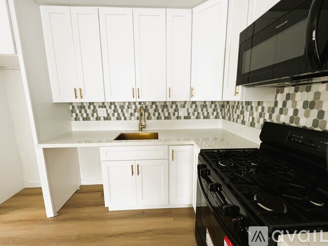 A kitchen with white cabinets and a black stove top oven.