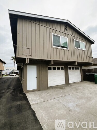 A two-story garage with a brown exterior and a white door.