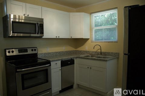 A kitchen with a black oven, white cabinets, and a granite countertop.