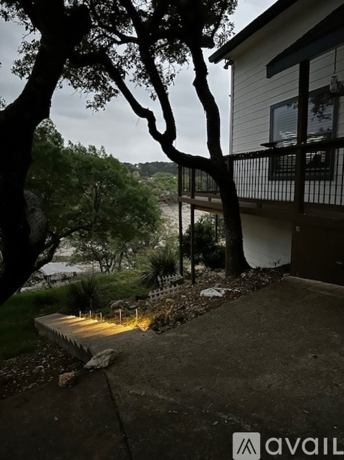 A house with a balcony and a tree in front of it.