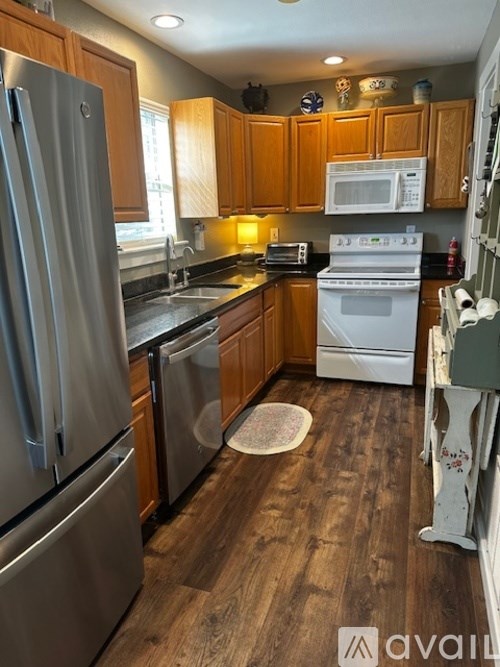 A kitchen with wooden cabinets and a white stove.