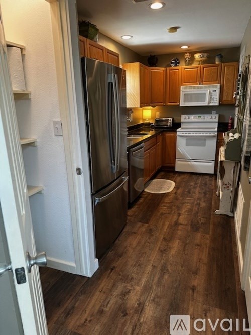A kitchen with wooden cabinets and a white fridge.