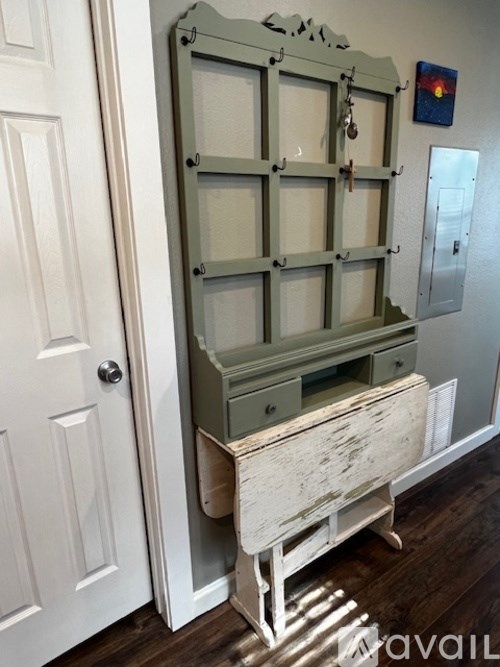 A tall wooden cabinet with glass panels and a drawer is in a room.