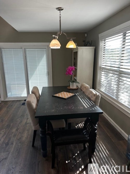 A dining room with a table and chairs.