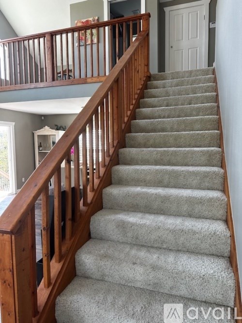 A staircase with a carpeted runner and wooden balusters.