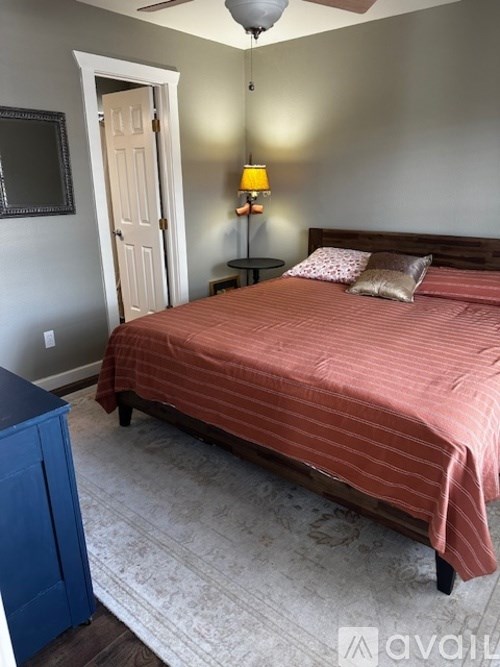 A bedroom with a bed, nightstand, and a ceiling fan.