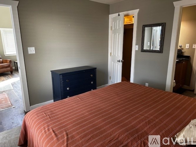 A bedroom with a bed, dresser, and mirror.