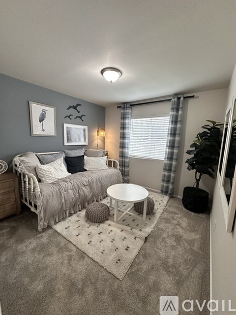 A living room with a grey sofa and a round table.