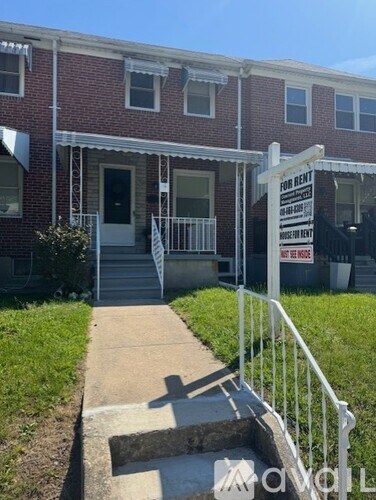 A red brick building with a for rent sign in front.