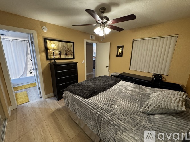 A bedroom with a bed, dresser, and ceiling fan.