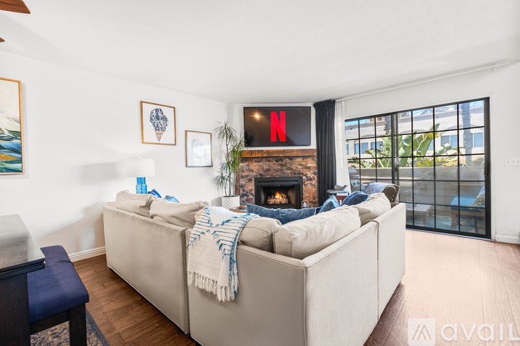 A living room with a couch, a fireplace, and a TV displaying the Netflix logo.