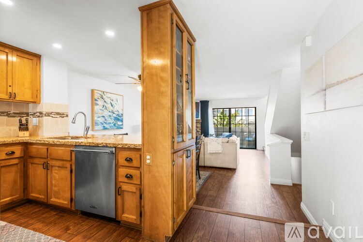 A kitchen with wooden cabinets and a refrigerator.