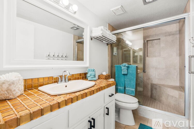 A bathroom with a white sink and a toilet.