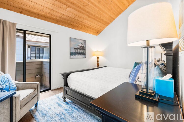 A bedroom with a bed, a couch, and a painting on the wall.