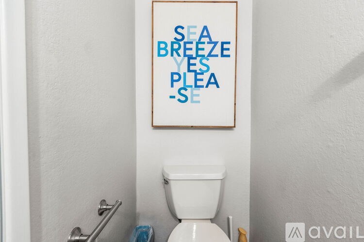 A bathroom with a toilet and a poster on the wall.