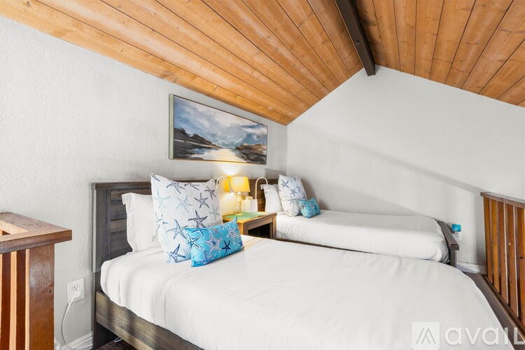 A bedroom with a bed, pillows, and a painting on the wall.