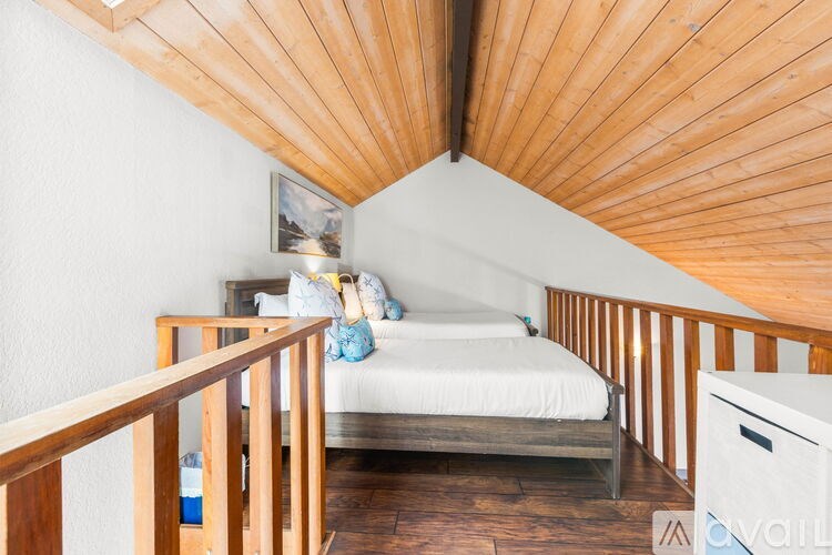 A bedroom with a bed, nightstand, and wooden ceiling.