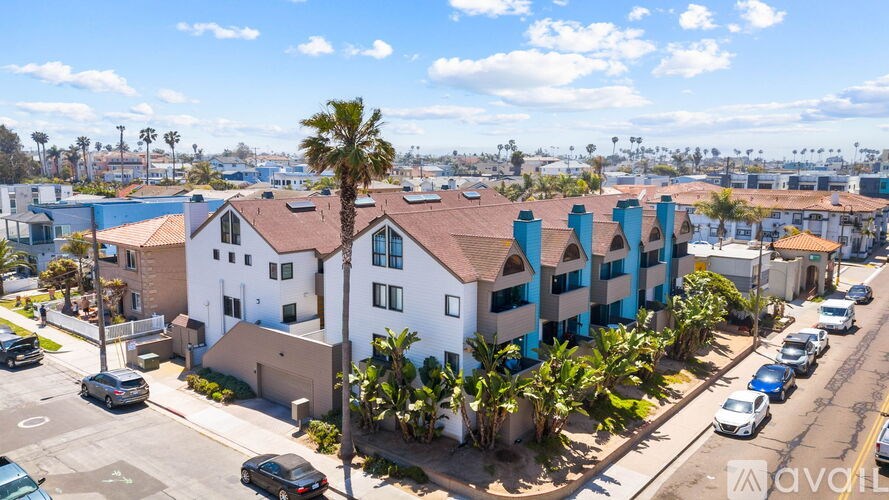 A building with a blue and white facade is surrounded by palm trees.