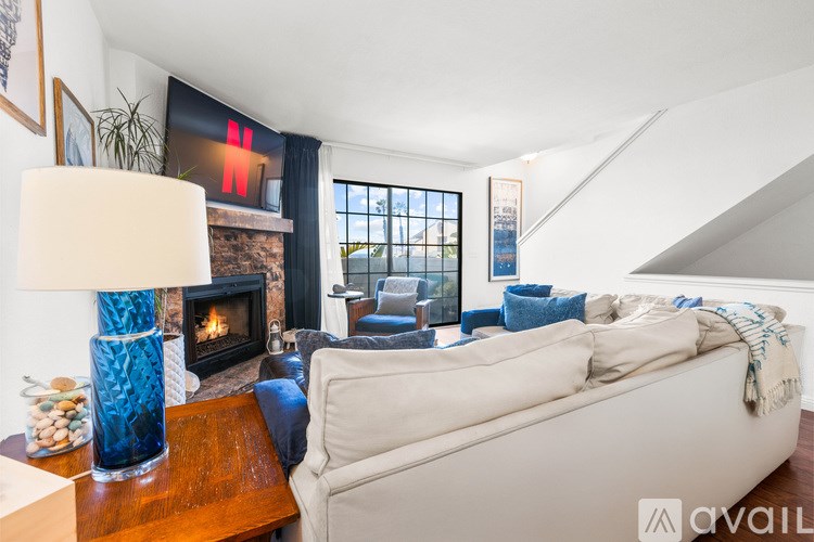 A living room with a white couch and a fireplace.