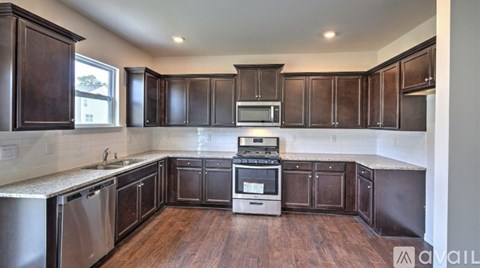 A kitchen with dark wood cabinets and stainless steel appliances.
