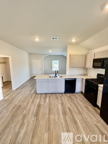 A kitchen with wooden flooring and modern appliances.