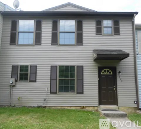 A house with a grey siding and a black door.