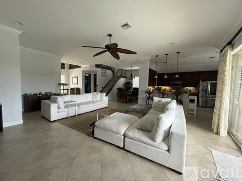 A living room with a white couch and a ceiling fan.