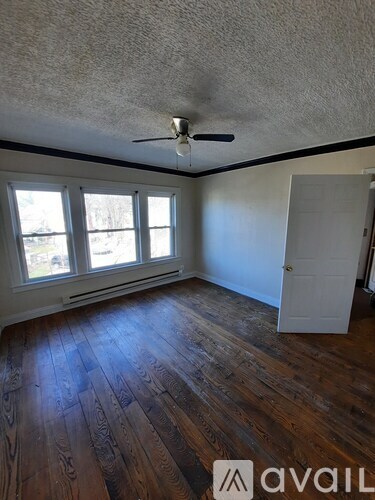 A room with wooden floors and a ceiling fan.