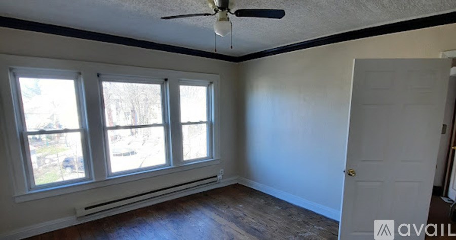 A room with a ceiling fan and a door.