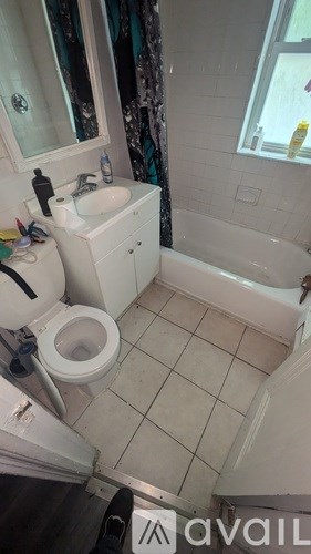 A bathroom with a toilet, sink, and bathtub.
