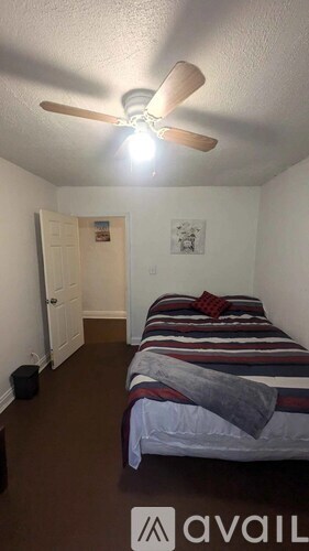 A room with a bed and a ceiling fan.