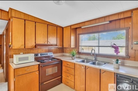 A kitchen with wooden cabinets and a stove top oven.