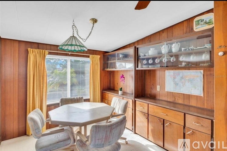 A dining room with a table and chairs.