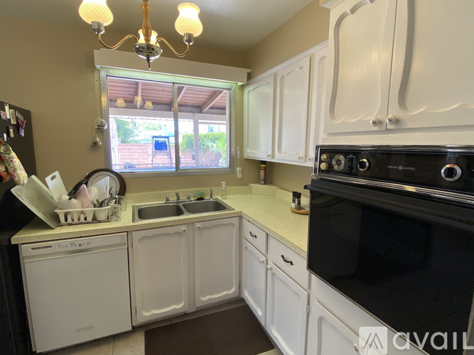 A kitchen with white cabinets and a black oven.