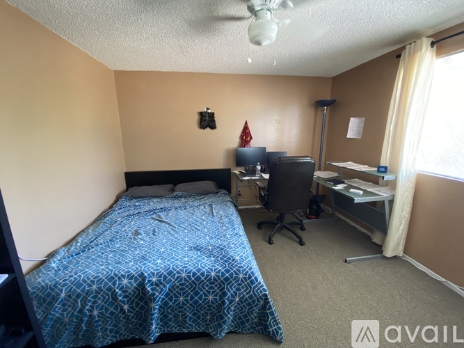 A bedroom with a bed, desk, and chair.