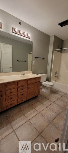 A bathroom with a toilet, sink, and mirror.