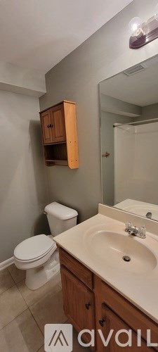 A bathroom with a toilet, sink, and medicine cabinet.