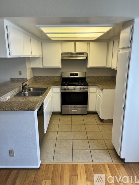 A kitchen with white cabinets and a granite countertop.
