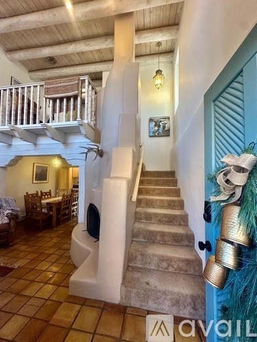 A white staircase with a blue door on the right side.