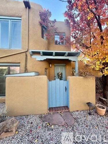 A small house with a blue door and a small porch.
