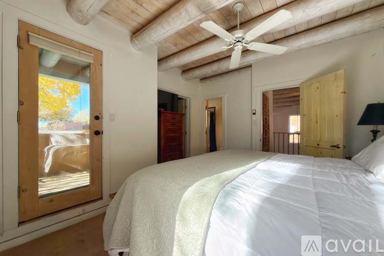 A bedroom with a large bed and a ceiling fan.