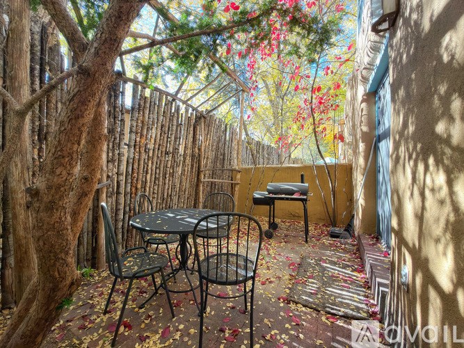 A patio with a table and chairs surrounded by a bamboo fence.